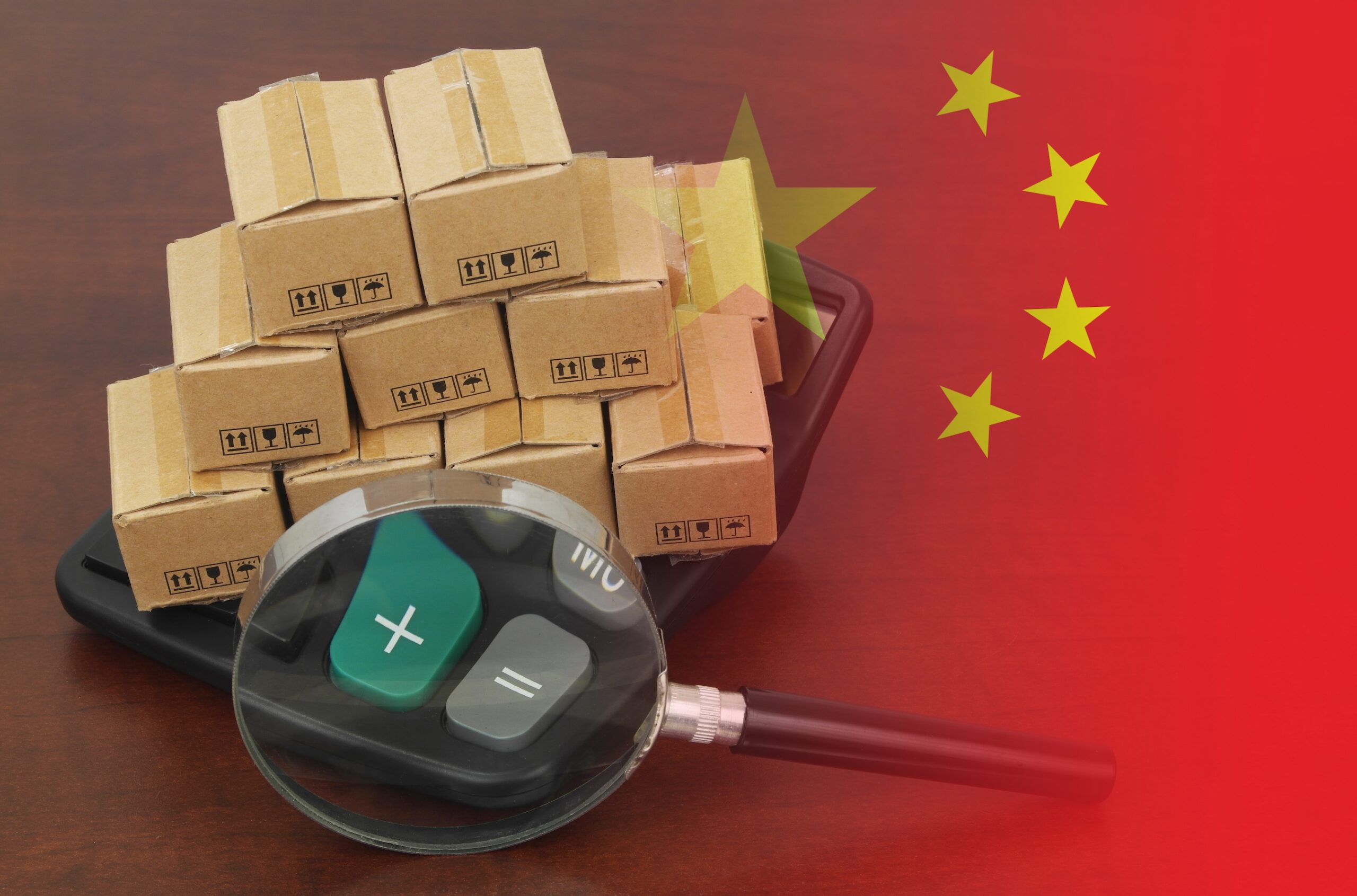 Vergrootglas, calculator, en stapel dozen met Chinese vlag voor export en logistiek concept.